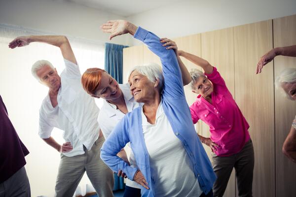 Group of seniors doing exercises with nurse