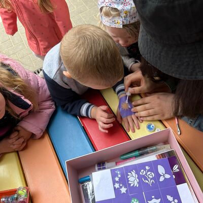 Die Kinder ließen sich glitzernde Bilder auf die Hände und Arme malen.