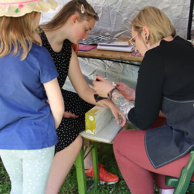 Kinder werden mit Glitzertattoos verziert