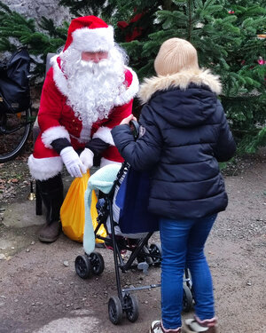 Der Weihnachtsmann verteilt Geschenke und Autogrammkarten
