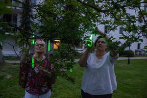 Dagmar Richter (l.) und Katrin Kraus bereiten die Knicklichtaktion im Garten des AWO Familien- und Pflegezentrums Am Kleers in Quedlinburg vor._k
