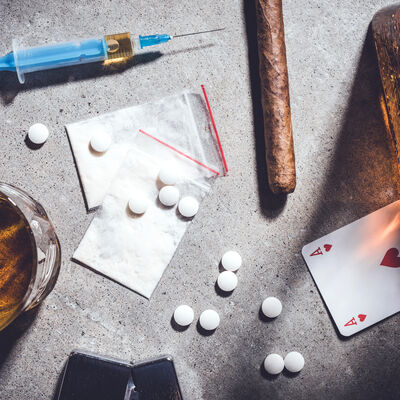 Hard drugs and alcohol on gray stone table. Top view