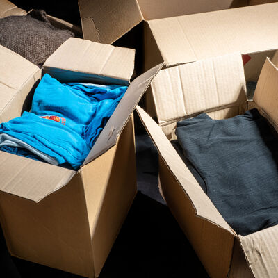 Donation concept. Donation box with donation clothes on a dark background. Charity. Help for people in need